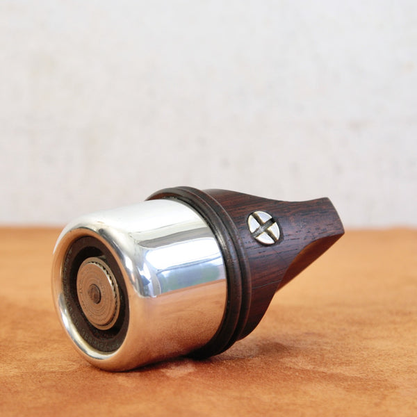 Iconic Rosewood & Silver series pepper mill laying on its side. Design by Jens Quistgaard, produced by Dansk Designs in the early 1970s.