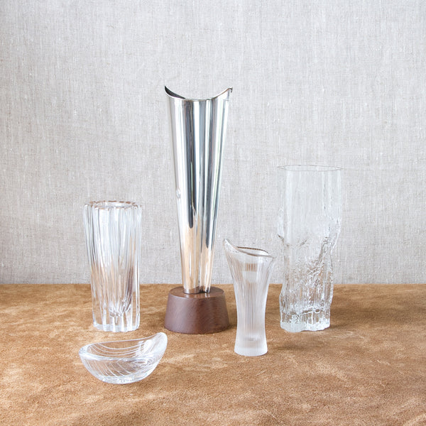 Group image of Tapio Wirkkala designs in glass and silver. The tall model TW228 vase was produced by Kultakeskus Oy. The four pieces of glass were all made by Iittala Glassworks in the 1950s and 1960s. Tapio Wirkkala was an enormously influential Modernist designer during the mid-20th century.
