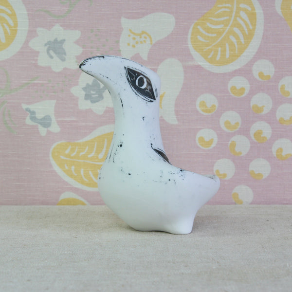 A large white ceramic bird figurine with black speckled details and a stylized eye. Collectable British art pottery by Susan Parkinson for the Richard Parkinson Pottery in Brabourne Lees, Kent.