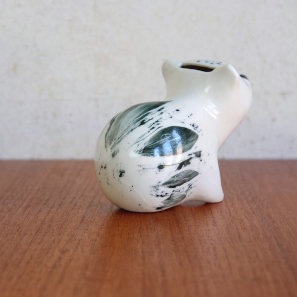 Rear view of a Susan Parkinson seated bear or panda money box, with subtle naturalistic decoration.