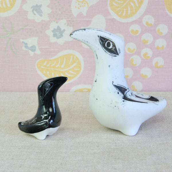 Two ceramic bird figurines, one glossy black and one matte white with black speckles. Both designs are British Modernist sculptures by Susan Parkinson, an under appreciated name in Post-War English design / decorative arts.