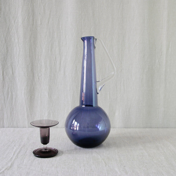 Tamara Aladin model 1749 lilac glass carafe, a collectible early Riihimäki Finnish design from 1960 for sale in the UK. Paired with purple Nanny Still Harlekiini candlestick. 