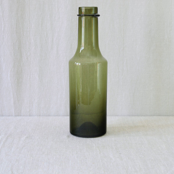 Tapio Wirkkala model 2507 bottle in olive green glass, with gently sloping shoulders, a long neck and distinctive applied glass ring.