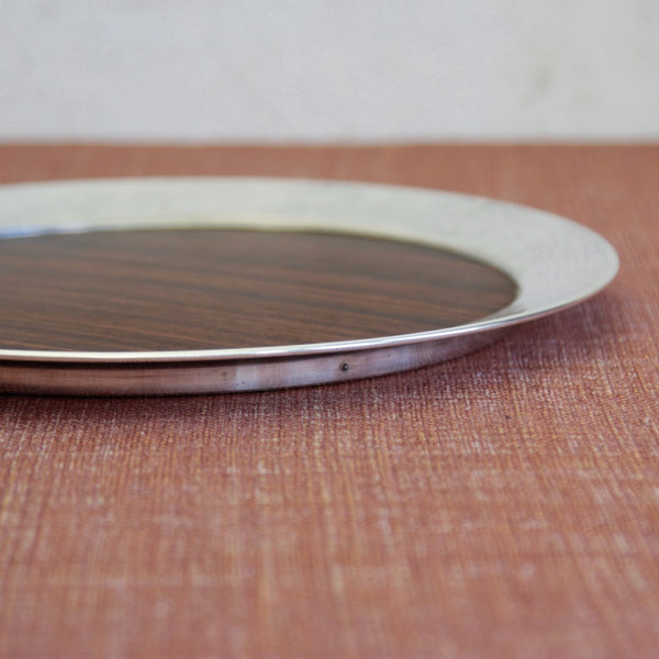 Detail of rim of a collectible Tapio Wirkkala salver with woven-pattern silver collar and macassar ebony disk