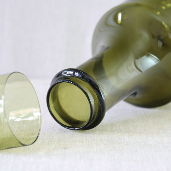 Detail of Tapio Wirkkala Rengaskaula bottle and wine glass set for Iittala Finland, designed as complementary pieces in olive green glass.
