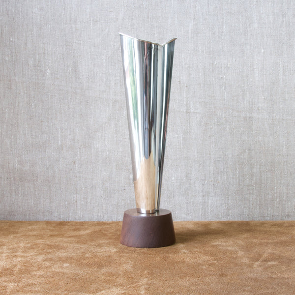 Head on shot of a highly polished sold silver vase designed by Tapio Wirkkala for Kultakeskus Oy. The surface of the silver vase is highly reflective.