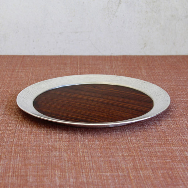 Top down view of a Scandinavian design tray by Tapio Wirkkala featuring hand-tooled silver rim and exotic ebony wood