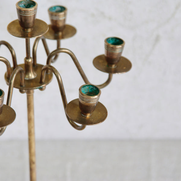Top down detail of the nicely patinated sconces and drips trays on a classic Swedish seven-arm brass candelabra, 1950s mid-century design with Nordic elegance.