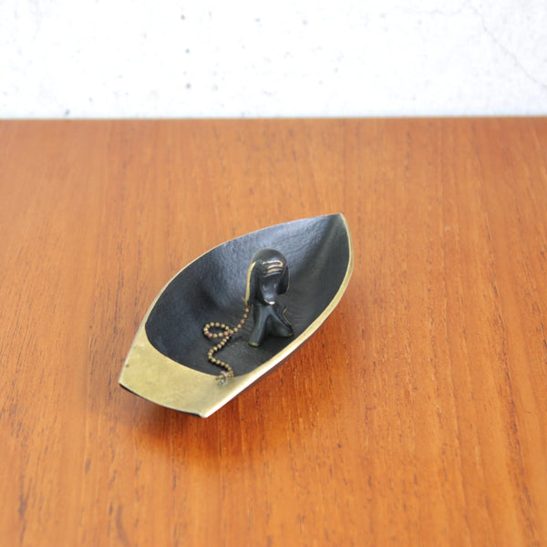 Top down view of a Walter Bosse brass dog figurine sat in the boat tray that it is attached too, early 1950s, Vienna Modernist collectible for interiors.