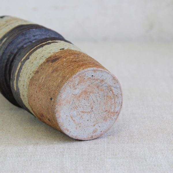 Close-up of a textured ceramic vase's base. The bottom of the vase is hand-signed by the maker, Nordic designer Annikki Hovisaari. Arabia, Finbland.