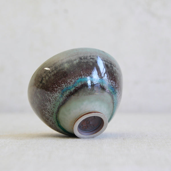 Mood shot showing the underside of a collector’s Friberg bowl for Gustavsberg featuring aubergine, turquoise and green glazes; a standout Swedish studio pottery piece.