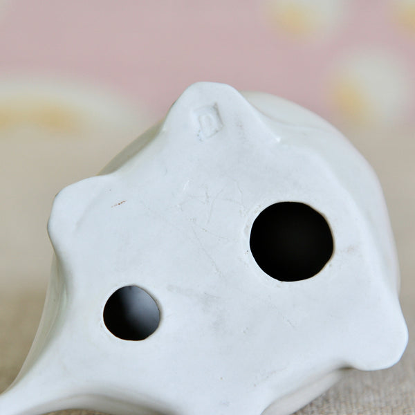A close-up of the base or underside of a Susan Parkinson porcelain Loch Ness Monster. The photo details the letter mark impressed into the ornaments front right leg/arm. The Parkinson Pottery is known for using only letter stamps on small objects like this.