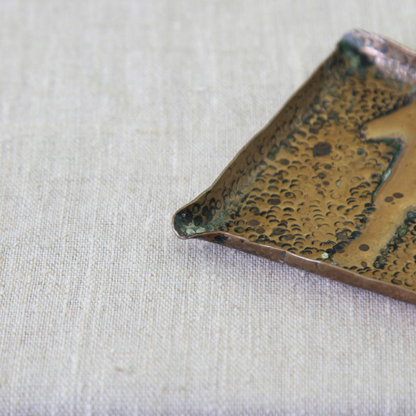 Detail shot of a unique naïve brass tray handmade in England circa 1950, featuring a stylised horse within a simple square form.