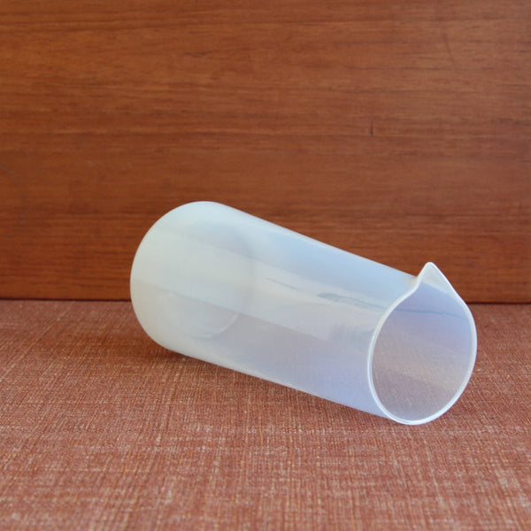 View of a 1950s Kastrup carafe by Jacob Bang laying down, showing its tall, tapered form. Rare and collectible iconic Danish design.