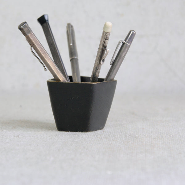 A Walter Bosse brass vessel displayed with silver antique pens, combining Viennese mid-century design with vintage writing instruments.