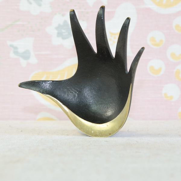 Herta Baller brass hand ashtray by Walter Bosse, with polished fingertips and lower palm contrasting against the dark patination.