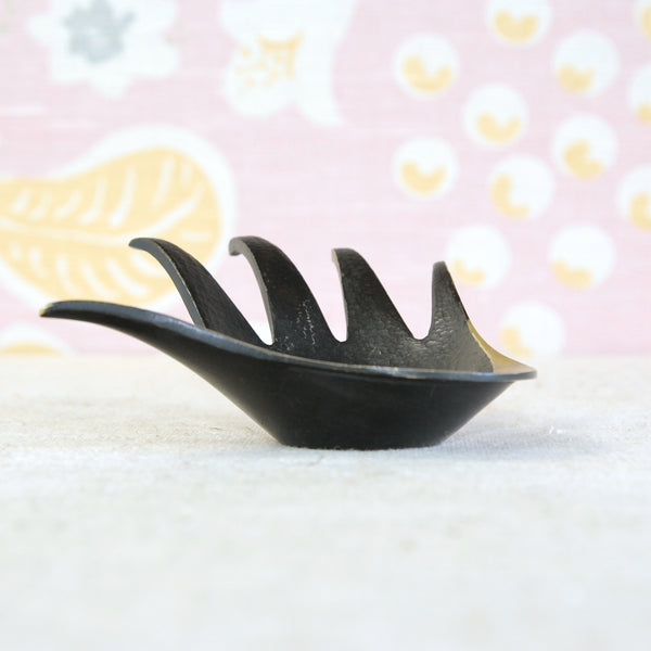 Sculptural Walter Bosse hand ashtray in handmade brass, with elongated fingers gently curved around the shallow bowl.