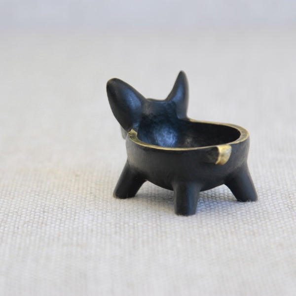 Walter Bosse brass pig with bowl, produced by Herta Baller, showcasing precise casting, drilled eyes, and restrained polished highlights.