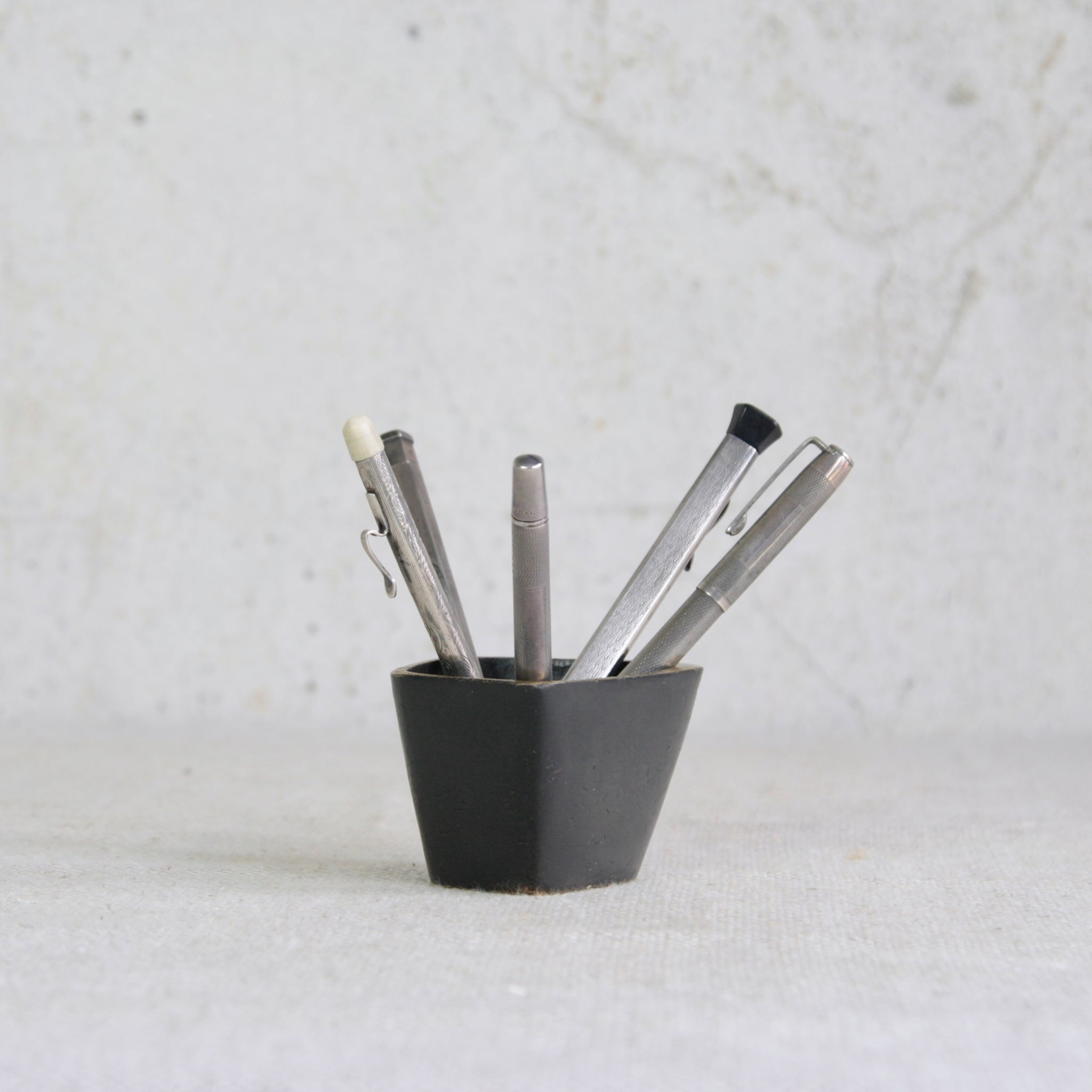 A Walter Bosse brass container produced by Baller Austria, mid-century Vienna, with sculptural modernist design. Shown with antique sterling silver pens and stationary. 