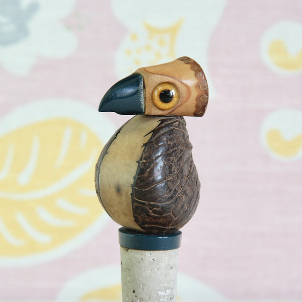 Art Deco tagua nut bird with navy blue phenolic resin beak and matching circular base