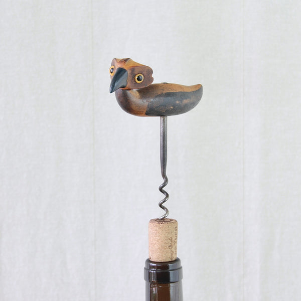Side view of a YZ bird corkscrew designed by Bernard Charles Howell, with the steel corkscrew extending beneath the wooden body as long legs.