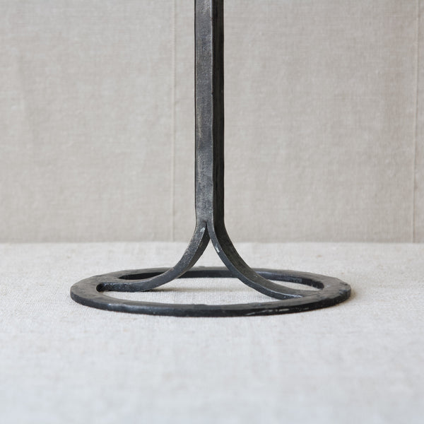 Head on shot of the circular foot of a black metal hand forged iron candelabrum designed by Bertil Vallien for Boda Smide. This collectable piece of midcentury modern design was made in the 1960s.