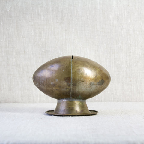 Antique brass trench art money box in the shape of a rugby ball