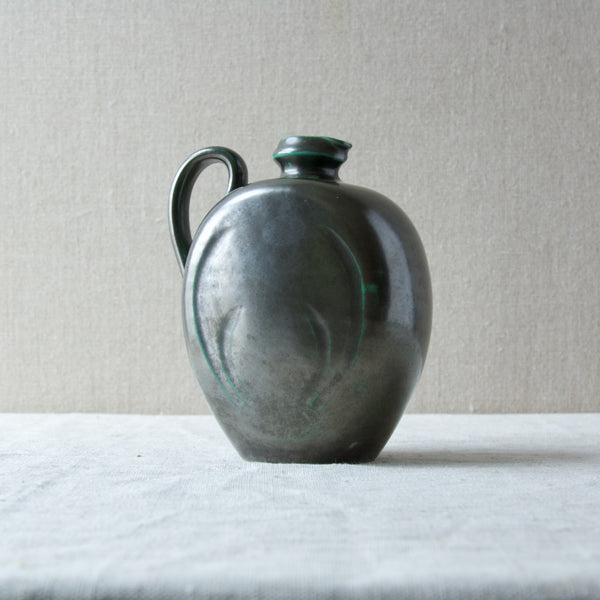 Side image showing the more flamboyant incised decoration related to Art Nouveau on this Art Deco shaped ceramic pitcher designed by Harald Östergren.