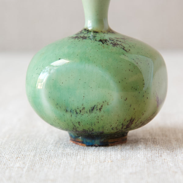 A small bright-green and deep-red glazed Berndt Friberg vase that has been paddled on four sides to create a gentle quadratic form. The Scandinavian ceramic vase’s elegant shape and glaze take inspiration from ancient Song Dynasty Chinese ceramics.