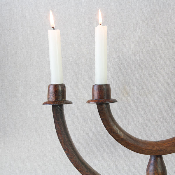Antique 1920's British folk art candelabra, a detail image of candle sconces and burning candles