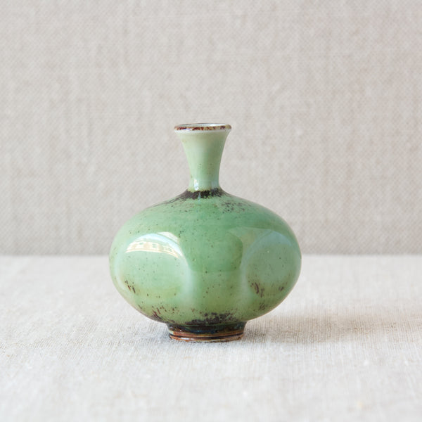 A head on shot showing the elegant shape of an exquisitely proportioned vase by leading Swedish ceramicist Berndt Friberg. The mid-20th century vessel features a fluted neck and its sides have been paddled.