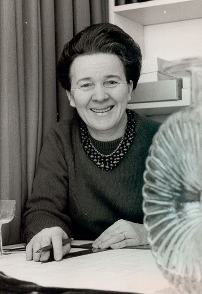 An original black and white portrait photograph of Finnish glass designer Helena Tynell, in the foreground we see half of an Aurinkopullo -perhaps her most famous work.
