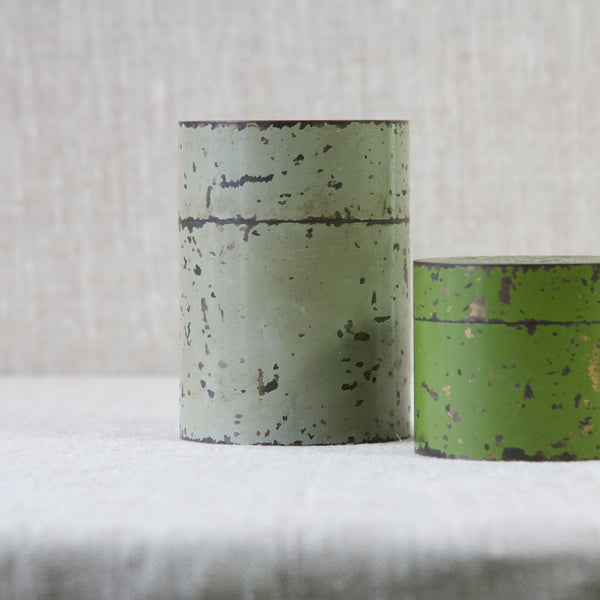 Close up showing the worn enamelled paint on a pair of brass canisters. These storage containers date from around 1925.