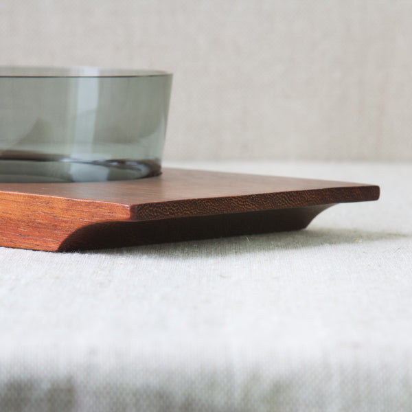 Detail showing the end grain of a teak tray that is carved with a curved carrying grip. The aforementioned curve follows the golden ratio. Design by Saara Hopea for Nuutajärvi Glassworks, 1955.