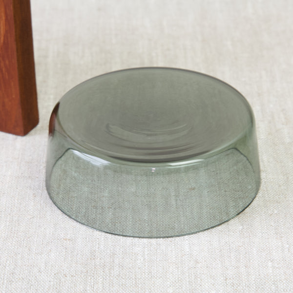 Saara hopea design. The smoke-grey coloured glass dish is shallow, and its walls subtly taper outwards at the top. 