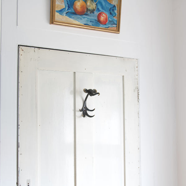 Wooden door with a whimsical brass Walter Bosse elephant coat hook, designed in the 1960's and produced in Germany