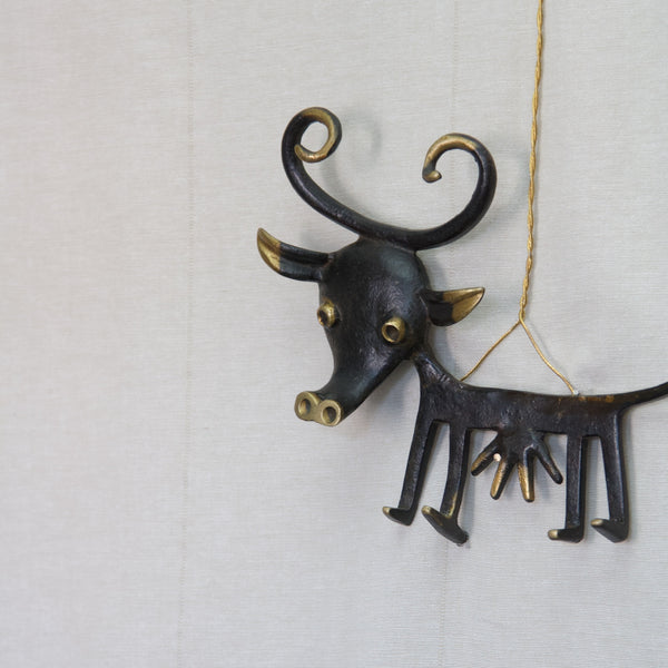 Modernist German cow key rack designed by Walter Bosse in patinated black brass with curly horns and an expressive face