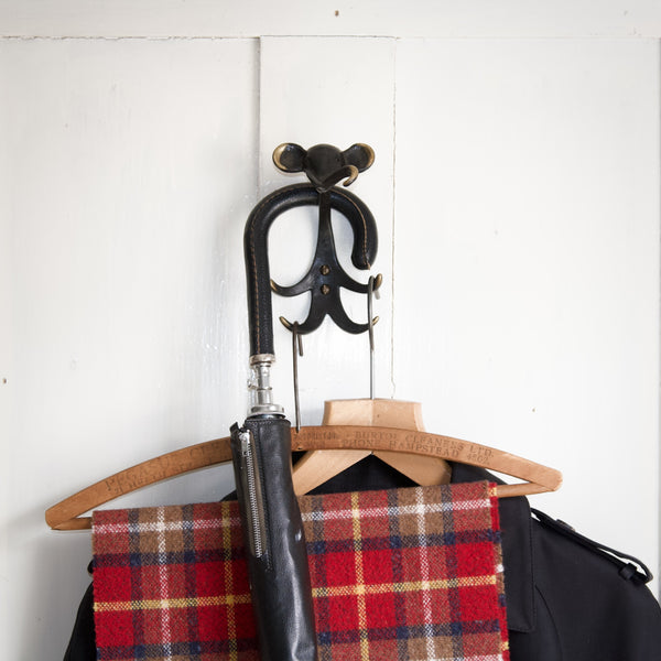 patinated metal elephant coat hook designed by Walter Bosse, holding a raincoat and tartan Drake's scarf